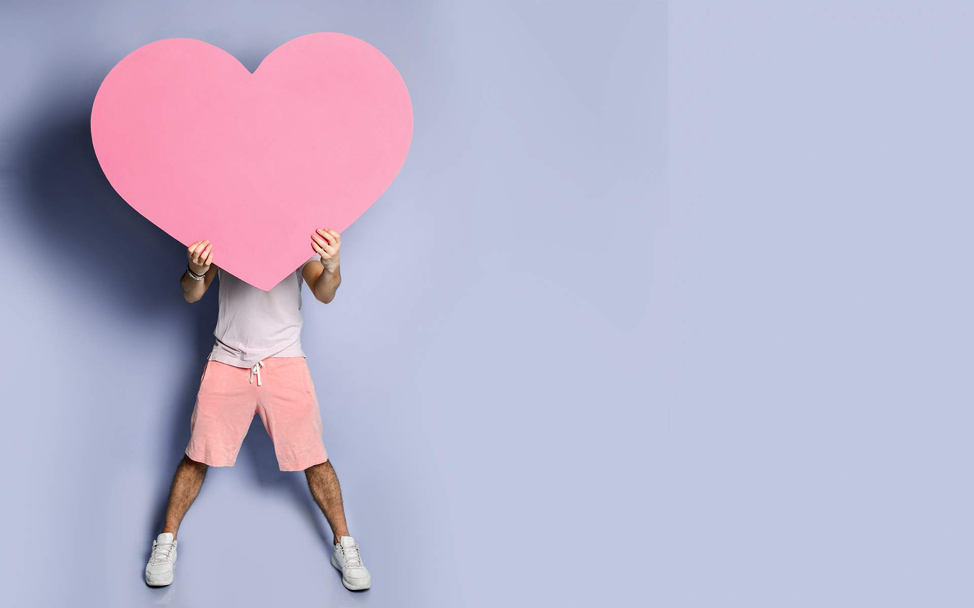 Loving-Kindness Guided Meditation - Young man hide his face behind pink heart shape toy in hands on